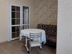 una camera con tavolo, sedie e divano di Elite Apartment in street Orozbekova 2 a Bishkek