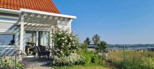 a porch of a house with a chair and flowers at Apartament Cztery Strony Mazur in Ryn