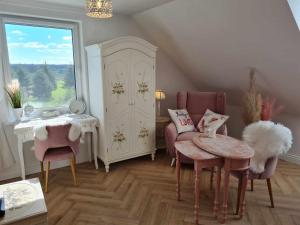 sala de estar con sillas, mesa y ventana en Apartament Cztery Strony Mazur, en Ryn