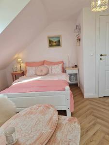 1 dormitorio con 1 cama con colcha rosa en Apartament Cztery Strony Mazur en Ryn