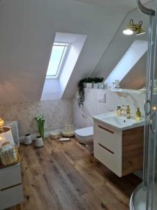 雷恩的住宿－Apartament Cztery Strony Mazur，阁楼浴室设有卫生间和水槽。