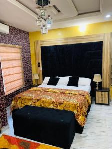 a bedroom with a large bed with a black headboard at Dsmarts apartments in Benin City