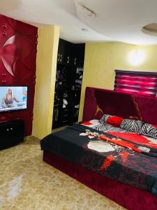 a bedroom with a bed and a flat screen tv at Dsmarts apartments in Benin City