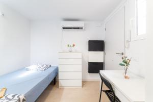 Un pequeño dormitorio con una cama y una cocina. en Casa Maruchi - Studio 1, en Almería