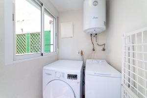 Un lavadero con lavadora y ventana. en Casa Maruchi - Studio 1, en Almería