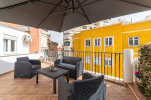 Un patio con sillas, una mesa y una sombrilla. en Casa Maruchi - Studio 1, en Almería