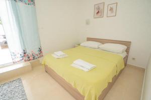 a bedroom with a bed with two towels on it at Apartmani Vidušin in Novalja