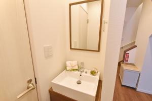 a bathroom with a white sink and a mirror at ID STAY Haneda in Tokyo