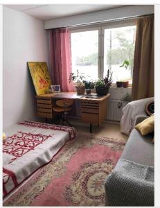 a bedroom with a desk and a window with a bed at Papula-huoneisto 