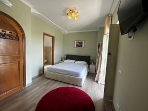 sypialnia z białym łóżkiem i czerwonym dywanem w obiekcie Villa Wuthering Heights w Rzymie