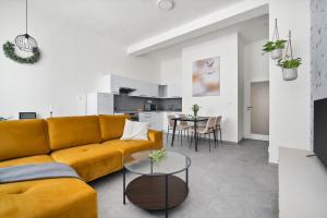 a living room with a yellow couch and a table at Enjoy Downtown Boutique Apartments #13 by Goodnite cz in Brno