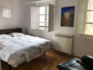 1 dormitorio con cama, ventana y sofá en Casa de los Chilenos en Oviedo
