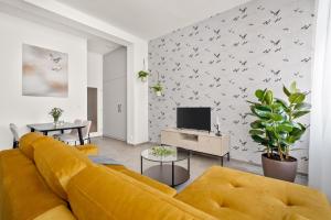 a living room with a yellow couch and a tv at Enjoy Downtown Boutique Apartments #13 by Goodnite cz in Brno