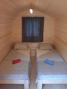 a room with two beds in a cabin with a window at Camping & Glamping Grintovec in Preddvor