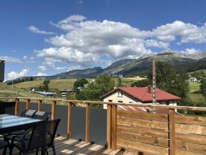 une terrasse avec une table, des chaises et des montagnes dans l'établissement Maison Villard-de-Lans, 5 pièces, 10 personnes - FR-1-548-38, à Villard-de-Lans