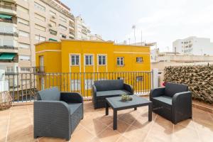 ein Balkon mit Stühlen und einem Tisch und einem gelben Gebäude in der Unterkunft Casa Maruchi - Studio 2 in Almería