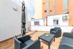 eine Terrasse mit Stühlen, Sonnenschirm und Tisch in der Unterkunft Casa Maruchi - Studio 2 in Almería + 31 Fotos