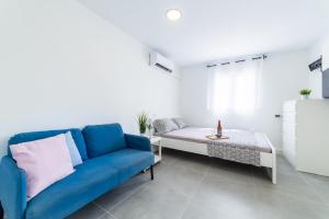 ein Wohnzimmer mit einem blauen Sofa und einem Tisch in der Unterkunft Casa Maruchi - Studio 2 in Almería