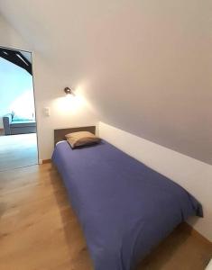 łóżko w pokoju z białą ścianą w obiekcie Gite Porte de Champagne Levroux w mieście Levroux