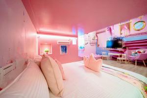 um quarto cor-de-rosa com uma cama grande e uma sala de jantar em Yilan 1955 B&B Second Branch em Wujie