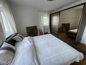 een slaapkamer met een groot wit bed en een spiegel bij Ferienwohnung in Maikammer in Maikammer