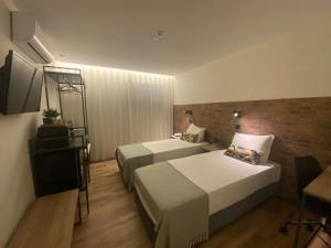 a hotel room with two beds and a television at Hotel Portucalense in Porto