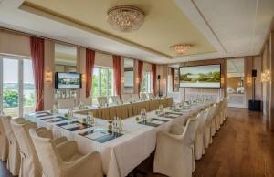 een grote vergaderzaal met een lange tafel en stoelen bij Hotel Louis C. Jacob in Hamburg