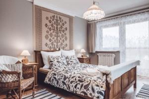 Un dormitorio con una cama grande y una lámpara de araña. en Willa Hamry, en Poronin