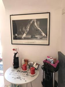 un tavolo con tazze e una foto sul muro di Massenzio's house a Lecco