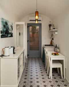 a kitchen with white counters and a table and chairs at Agorà-ARCUNE in Fasano