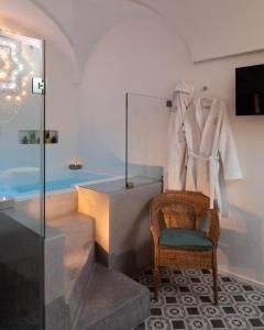 a bathroom with a wicker chair and a bath tub at Agorà-ARCUNE in Fasano