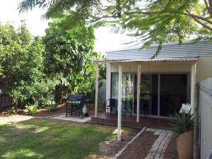 a house with a screened in porch with a grill at Bluegrass BnB in Bundaberg