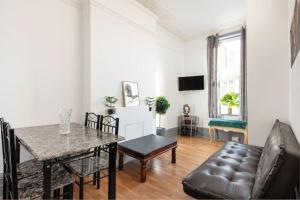 a living room with a table and a couch at 2A - Bright & Airy 2 Bed Flat - 20 Mins to Central in London