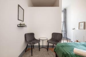 two chairs and a table in a bedroom at 2A - Bright & Airy 2 Bed Flat - 20 Mins to Central in London