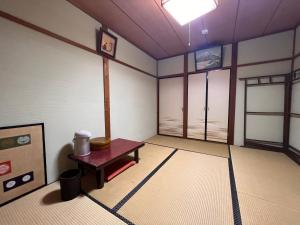 Cette chambre dispose d'une table et de fenêtres. dans l'établissement Ryokan Sanki, à Kyoto