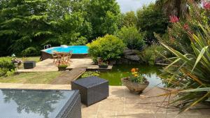 um quintal com uma piscina e um jardim em Au bon endroit em Sevremont