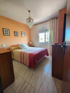 1 dormitorio con 1 cama con manta roja y ventana en Apartamento en la playa, en Cunit