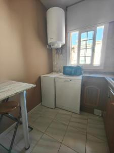 una pequeña cocina con mesa y ventana en Apartamento en la playa, en Cunit