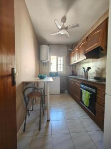 cocina con armarios de madera y ventilador de techo en Apartamento en la playa, en Cunit