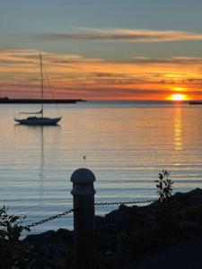 um veleiro na água ao pôr do sol em Family villa in suburban Reykjavik em Hafnarfjördur