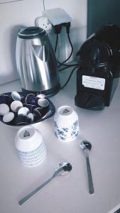 a counter with a coffee maker and spoons on it at Garden and Pool at Royal Park Eilat in Eilat