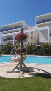 a basket of flowers sitting in front of a building at Garden and Pool at Royal Park Eilat in Eilat