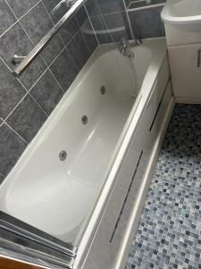 a white bath tub in a bathroom next to a toilet at Home from Home in London