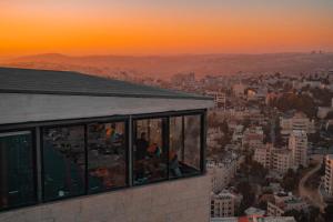 een uitzicht op de stad bij zonsondergang vanuit een gebouw bij Carmel Hotel in Ramallah