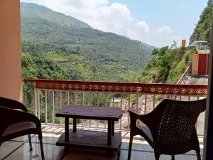 einen Tisch und Stühle auf einem Balkon mit Aussicht in der Unterkunft Hotel Red Roof & Restaurant in Abbottābād