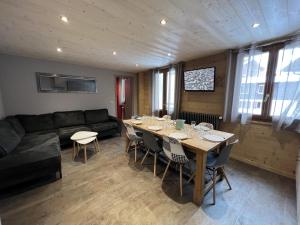 a dining room with a table and a couch at GENTIANES 2 - Appartement centre village et proche pistes de ski - Wifi in La Clusaz