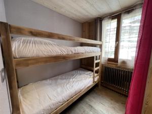 a couple of bunk beds in a room with a window at GENTIANES 2 - Appartement centre village et proche pistes de ski - Wifi in La Clusaz