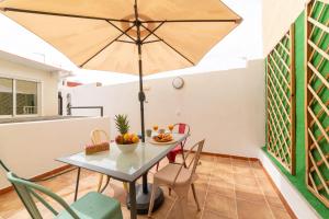 a dining room with a table and an umbrella at Casa Maruchi - Apartamento in Almería