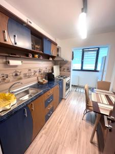 a kitchen with a sink and a table in it at CRISTAL Home Boutique Apartment 1 - Confort, Spatios, Linistit, Zona de interes in Craiova