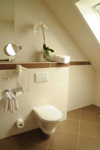 uma casa de banho com WC e um vaso com flores em Beierleins Hotel & Catering GMBH em Reichenbach